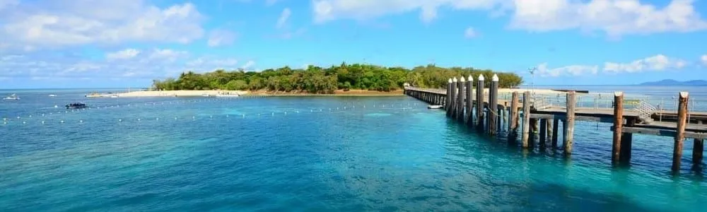 A timber jetty running out to Green Island, a coral cay ringed by turquoise water off Cairns